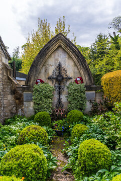 Historic War Memorial with ornate ironwork and lush greenery in Castle Combe, Wiltshire, England, within the Cotswolds.