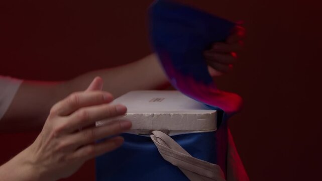 Close-up of human hands opening portable blue thermal bag, releasing cold vapor from dry ice, retrieving frozen gel pack for cooling. Concept of organ transport, food delivery. Shooting in slow motion