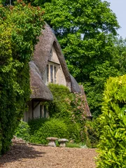 Historic thatched cottage nestled amongst lush greenery in the picturesque village of Castle Combe, Wiltshire, England. © steheap