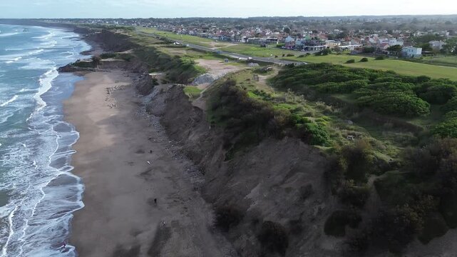 aerial drone view of ocean coastal road and city, cinematic aerial drone footage of ocean coastline, coastal road with moving cars, green trees and urban cityscape. scenic waterfront landscape in arge