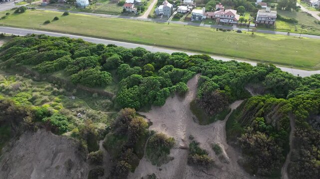 aerial drone view of ocean coastal road and city, cinematic aerial drone footage of ocean coastline, coastal road with moving cars, green trees and urban cityscape. scenic waterfront landscape in arge