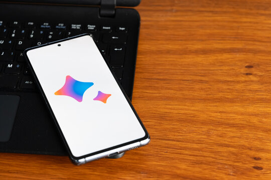 Punta Arenas, Chile &ndash; July 7, 2026: The Google Gemini artificial intelligence logo displayed on a smartphone screen resting on a laptop keyboard over a wooden table background