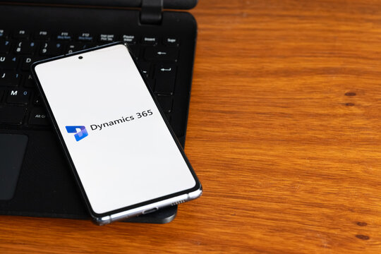 Punta Arenas, Chile &ndash; July 8, 2026: The Microsoft Dynamics 365 business applications logo displayed on a smartphone screen resting on a laptop keyboard over a wooden table background