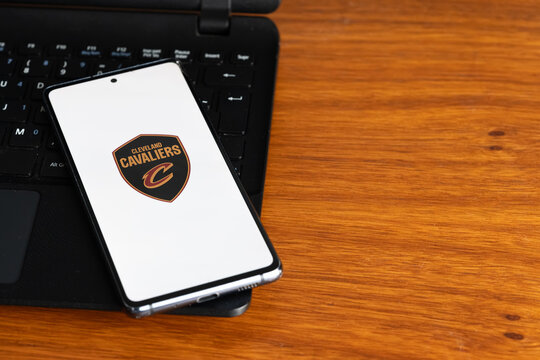 Punta Arenas, Chile &ndash; July 8, 2026: The Cleveland Cavaliers NBA basketball team logo displayed on a smartphone screen resting on a laptop keyboard over a wooden table background