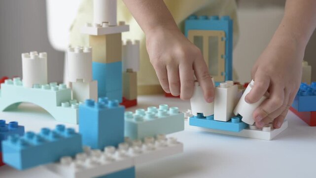 Young child builds colorful block structure while practicing independent learning, problem solving. Educational exercise strengthens attention, foundational skills for preschool and elementary school