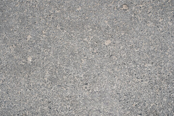 Gray asphalt road surface showing rough texture © EdienuFoto