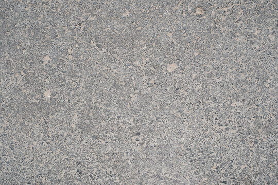 Gray asphalt road surface showing rough texture