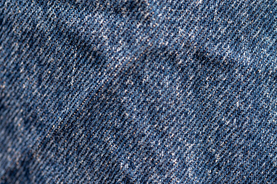 Close-up of blue denim texture. Seamless fabric pattern for fashion design background.Abstract background of washed blue denim cloth. Vintage textile surface details.