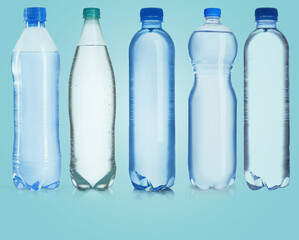 Naklejka premium Bottles of water on light blue background, set