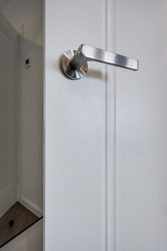 door handle on white wooden door in interior. Knob close-up elements. Door handle, fittings for interior design