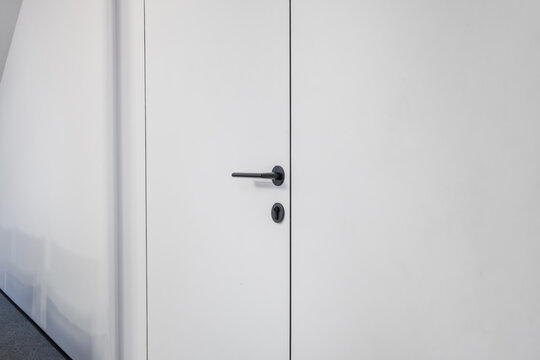 door handle on white wooden door in interior. Knob close-up elements. Door handle, fittings for interior design