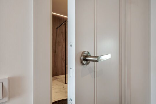 door handle on white wooden door in interior. Knob close-up elements. Door handle, fittings for interior design