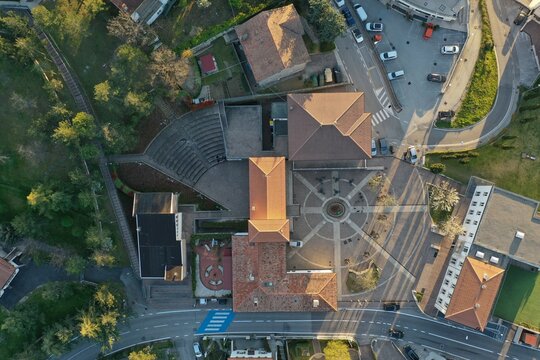 Aerial view of the town square featuring a circular paved plaza, terracotta-tiled rooftops, and an amphitheater area in Chiesanuova, Chiesanuova, San Marino.