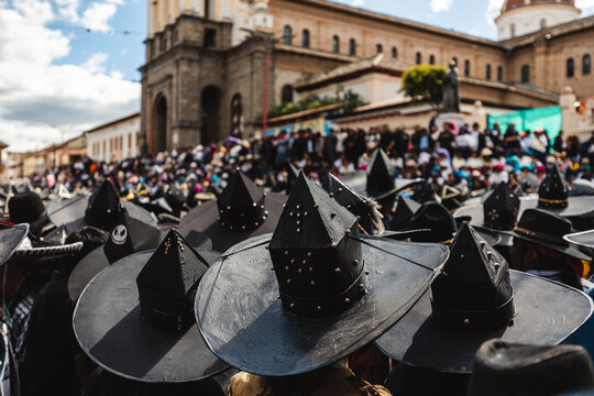 Indigenous dancers wearing traditional big black hats celebrating Inti Raymi festival in the main square of Cotacachi, Ecuador