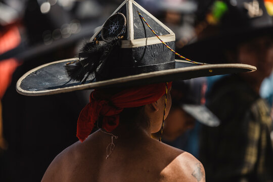 Rear view of an indigenous dancer wearing a decorated traditional large black hat at the Pachamama harvest festival