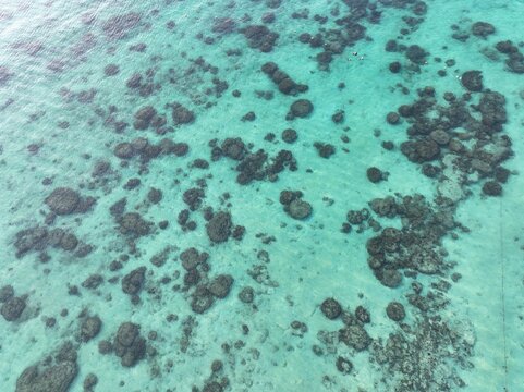 Aerial view of the coral reef surrounding Koh Khai Nok with clear turquoise water in Phru Nai, Phang Nga, Thailand.