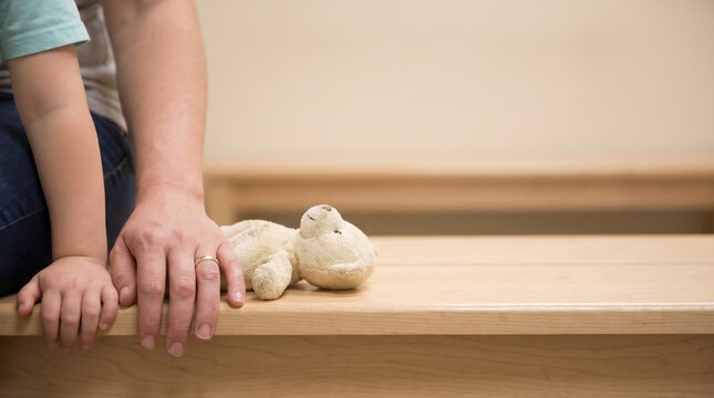 Anonymous child and parent hands in pediatric clinic waiting area