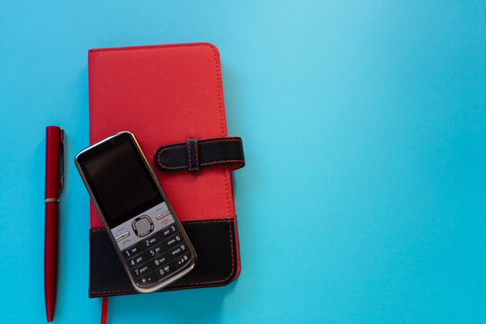 Small Paper Planner with Pen and Old Mobile Phone Evoking the Nostalgia of Written Notes
