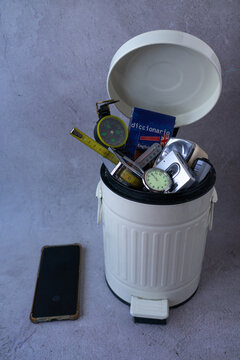 Container full of everyday objects replaced by the mobile phone which stays out-side as a symbol of technological dependence