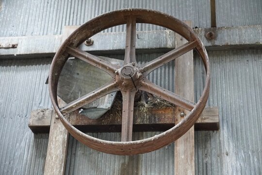 A large pulley wheel in an abandoned warehouse 