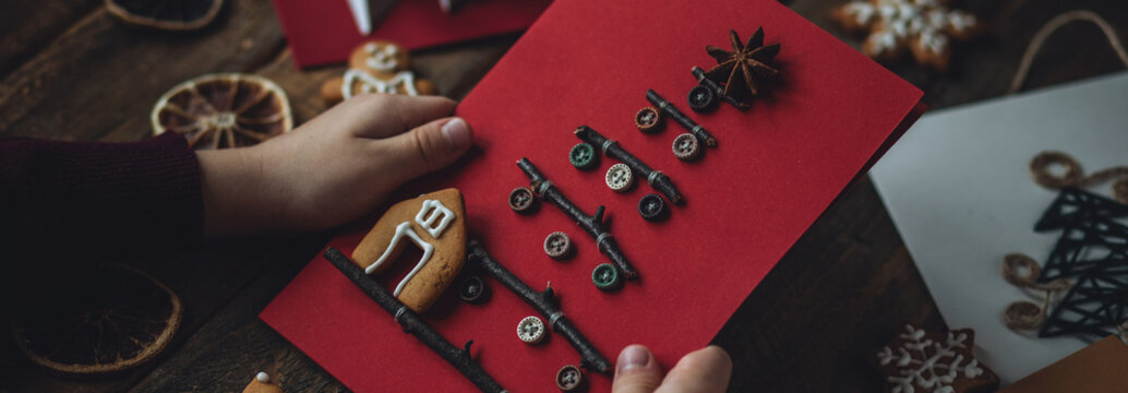 Banner. Concept of christmas leisure, family time, original do it yourself present. Little boy holding handmade card made with recyclable natural materials, zero waste, sustainable lifestyle, hobby.
