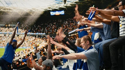 Blue team football supporters clapping and raising arms in crowded stands during exciting live soccer match, Sports fans with face paint creating loud crowd chants, game excitement. © DC Studio