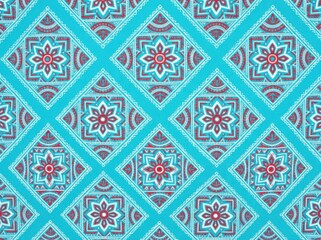 Fototapeta premium Seamless pattern with mandala style floral motifs in red and white on a bright turquoise background