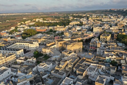 Aerial view of the historic town of Alessano with its dense stone architecture, narrow streets, and central church in Alessano, Apulia, Italy.