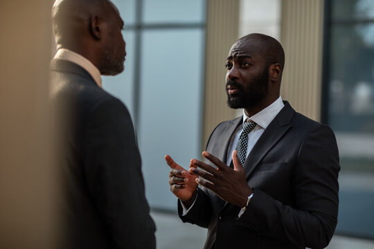 Two business professionals discussing outside modern office
