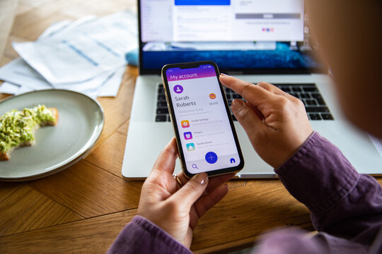 Person using mobile banking app at home office