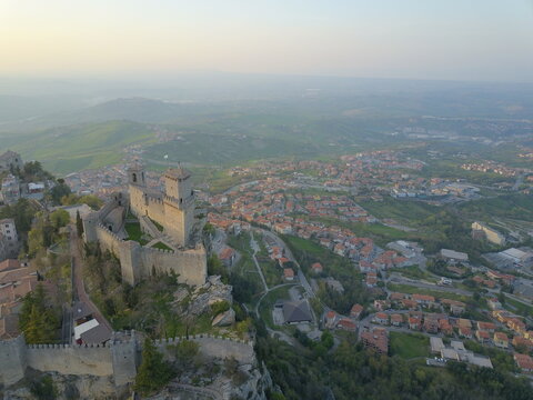 Aerial view of Guaita Tower perched on the rocky cliffs of Mount Titano overlooking the historic city and surrounding landscape in Citta di San Marino, San Marino, San Marino.