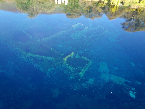 Aerial view of the submerged ruins of an ancient mill visible through the crystal clear blue water of Lago Di Capodacqua in Capestrano, Abruzzo, Italy.