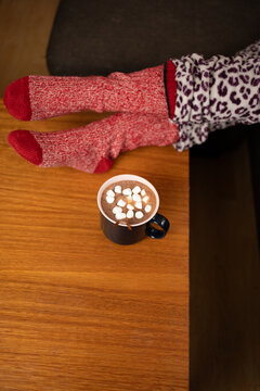 Relaxing at home with warm drink and comfortable knitted wool socks