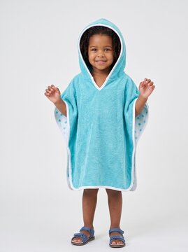 Young girl smiling and playing in a hooded bath towel poncho  