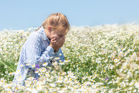 Little girl standing in field among daisies and sneezing. due to allergies, capturing the natural reaction to pollen exposure. Health, allergy awareness, pharmaceutical marketing, pediatric healthcare