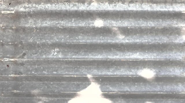 Animation sunlit casts shadows on the old corrugated iron roof, rusty texture, sunflare shadow motion background. Copy space with 4K video.

