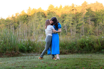 Women kissing in a clearing © Marissa