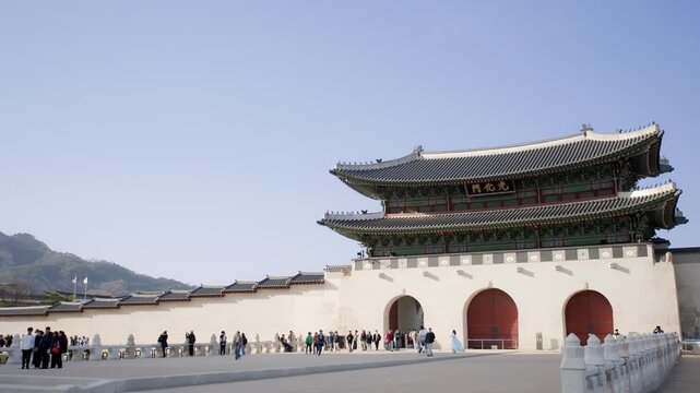 A close-up view of the traditional curved rooftop of Gwanghwamun Gate with its ornate tile work against a clear blue sky.