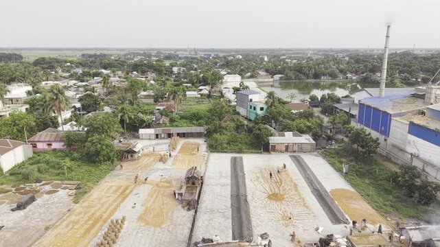 Forward drone footage capturing a large rice processing complex and industrial landscape in Khajanagar, Kushtia, Bangladesh.