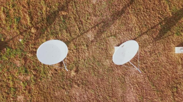 Direct overhead drone shot of a grid of twelve white parabolic satellite antennas located at the University of Bras&iacute;lia (UnB) Gama campus
