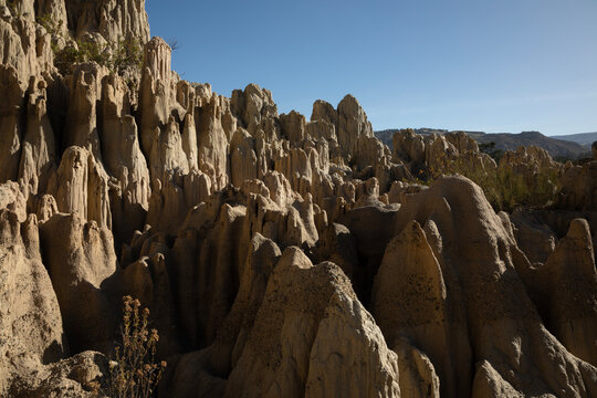 A close-up view of a splintered mountain on a sunny day. There are deep, abrupt gaps within the rock, making them look like massive mountain splinters.
