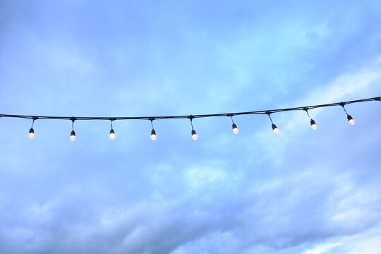 decorative string light hanging outdoors under a clear daylight sky
