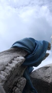Witness a sacred blue Khadag draped upon weathered stones in the breathtaking Khuvsgul mountains, Mongolia. This timeless blessing whispers tales of deep reverence beneath a serene cloudy sky.