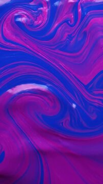 Vibrant blue and magenta liquid mixing in a slow swirling motion creating abstract art