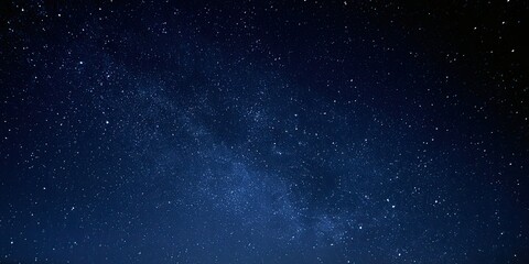 Fototapeta premium A deep blue night sky is filled with countless twinkling stars and a faint milky way