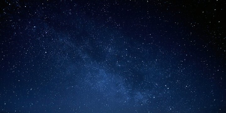 A deep blue night sky is filled with countless twinkling stars and a faint milky way