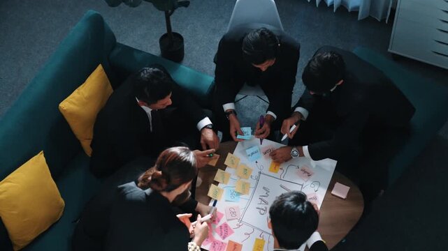 Top view of professional business team putting hands together and clapping hands to celebrate successful project while using mind mapping to brainstorm idea. Represented love and unity. Directorate.