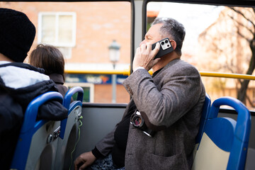 Man on public bus talking on smartphone © Nazareno