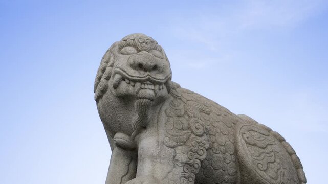 A close-up of a stone lion or Haechi guardian statue against a clear blue sky at Gwanghwamun Plaza in Seoul.