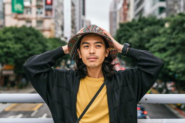 Fototapeta premium Young asian man portrait wearing bucket hat in city